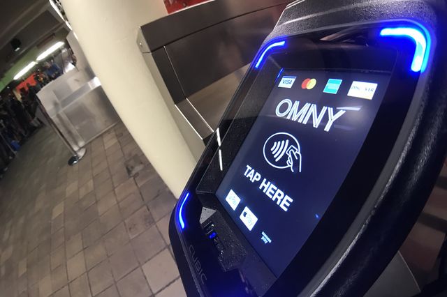 A close-up of the OMNY reader at a subway turnstile